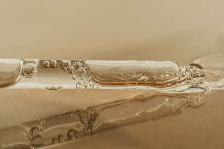 The texture of serum or oil with a pipette on a beige background.の写真素材