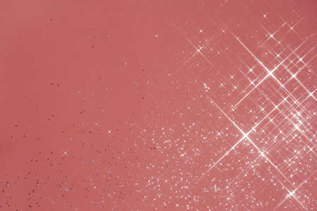 Abstract coral background with sparkles in the shape of stars.の写真素材