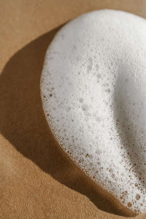 Texture of white foam on a beige background.の写真素材
