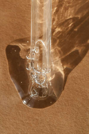 The texture of serum or oil with a pipette on a beige background.の写真素材