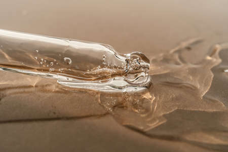 The texture of serum or oil with a pipette on a beige background.の写真素材
