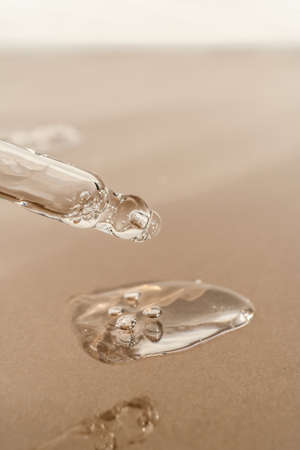 The texture of serum or oil with a pipette on a beige background.の写真素材