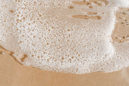 Texture of white foam on a beige background.の写真素材