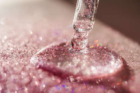 The texture of the serum or oil on an emerald background.の写真素材