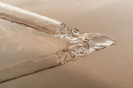 The texture of serum or oil with a pipette on a beige background.の写真素材