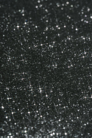 Abstract black background with sparkles in the shape of stars.の写真素材