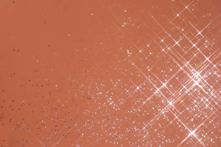 Abstract coral background with sparkles in the shape of stars.の写真素材