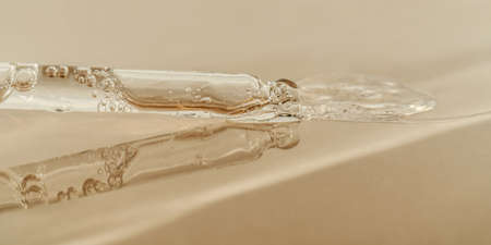 The texture of serum or oil with a pipette on a beige background.の写真素材