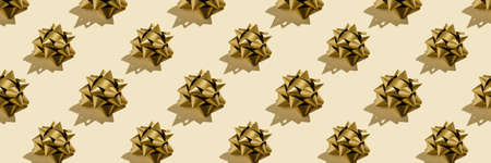 A pattern of many yellow gift bows. Banner.の写真素材