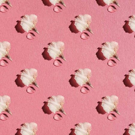A drop of water or cosmetics from a delicate petal on a pink background. Pattern.の写真素材