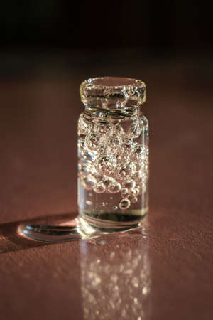 A bottle of cosmetic gel on a pink background.