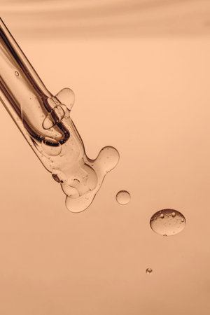 Pipette with cosmetic product in water with bubbles.