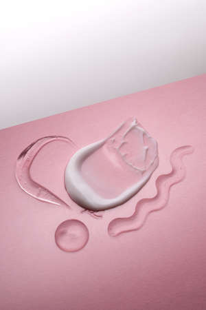 Serum and cream on a pink background. Textures.