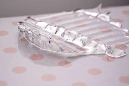 Transparent hyaluronic gel on a pink polka dots background.
