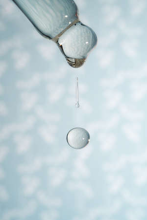 A dripping pipette with a drop of cosmetics gel.の写真素材