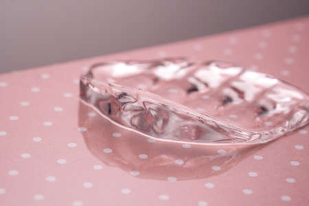 Transparent hyaluronic gel on a pink polka dots background.