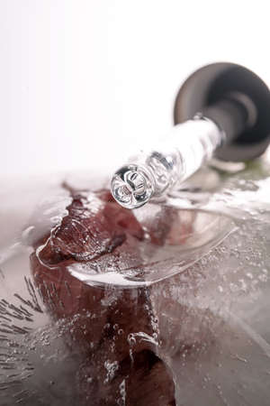 Pipette on a large piece of ice with frozen flowers.の写真素材