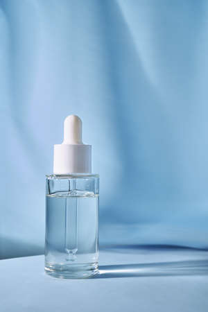 Transparent bottle of cosmetic gel on a blue background.の写真素材