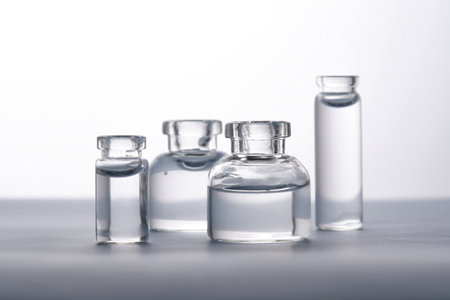 Different bottles of water on a light background. It can fit the theme of cosmetics, glass and...