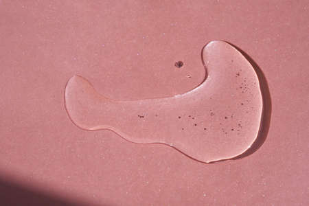 A drop of cosmetics or perfume on a pink background.の写真素材