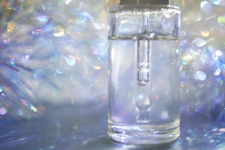 A bottle of serum with a pipette in tinsel in a Christmas theme in purple shades.の写真素材