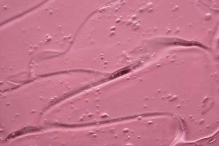 The texture of the cosmetic gel on a pink background.の写真素材