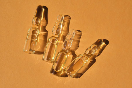 Glass ampoules on a beige orange background.の写真素材