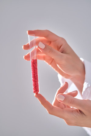 The girl is holding a test tube with red hearts.の写真素材
