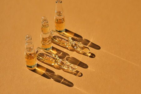 Glass ampoules on a beige orange background.の写真素材