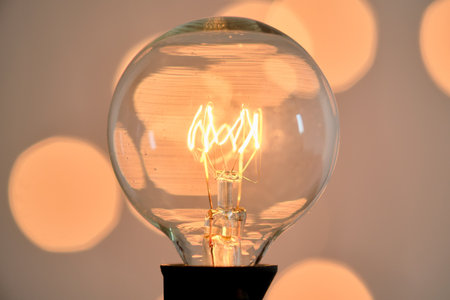 Incandescent light bulb with christmas round bokeh.