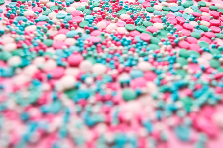 Multi-colored confectionery topping on a pink.の写真素材