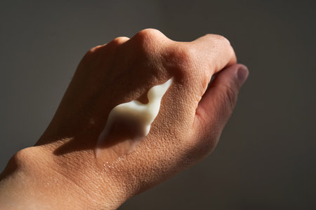 A smear of white moisturizer or sunscreen on a womans hand.の写真素材