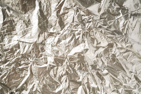 Abstract background made of crumpled silver foil.の写真素材