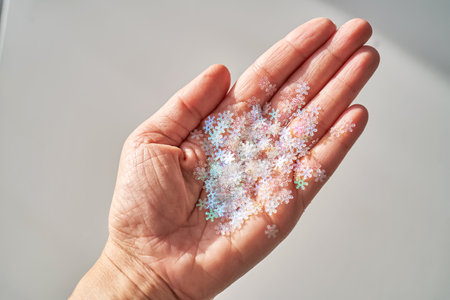 Sequins in the shape of snowflakes on the hand.の写真素材