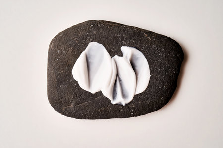 A smear of white cream on a black stone.