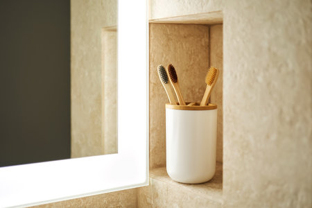 Natural bamboo toothbrushes in a glass in the bathroom.の写真素材