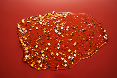 Cosmetic gel with glitter on a burgundy background.