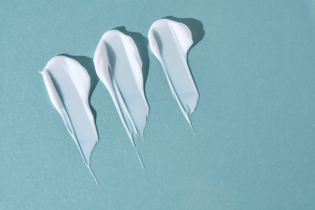Three strokes of white cream on a blue background.の写真素材