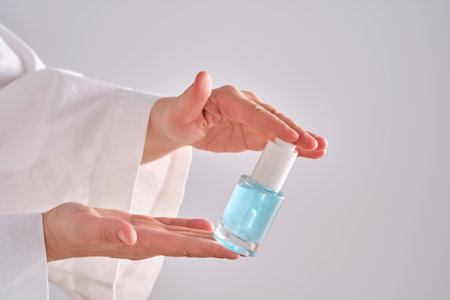 Blue serum with pipette in a womans hands in a robe.の写真素材