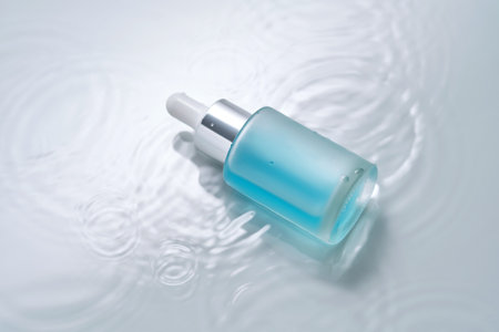 Bottles of cosmetics with a dropper in water on a blue background.