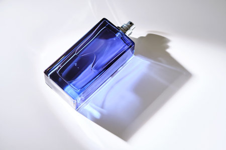Perfume spray in a blue bottle on a white background.の写真素材