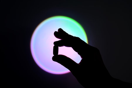 Tablet in hand against the background of a glowing circle. Silhouette.