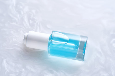 Bottles of serum with a dropper in liquid with pearl tints.