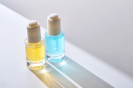 Yellow and blue serums with pipettes against the background of the sun.の写真素材