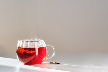 Glass mug with hot black tea on the table.の写真素材