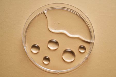 Serum or cosmetic oil flows into a transparent bowl.の写真素材