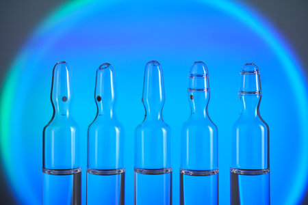 Several ampoules for injection with medicines on a blue background.の写真素材