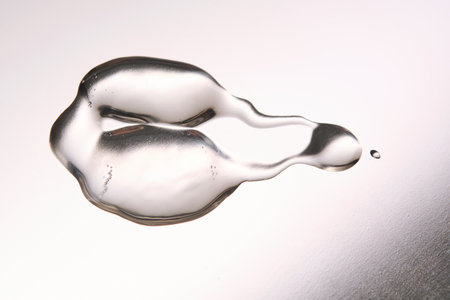 A smear of cosmetic gel close-up on a gray background. Appetizing texture with bubbles.