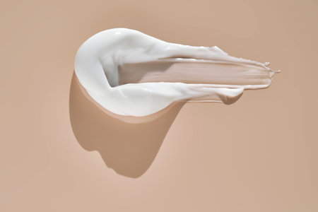 A smear of white cream on a beige background.