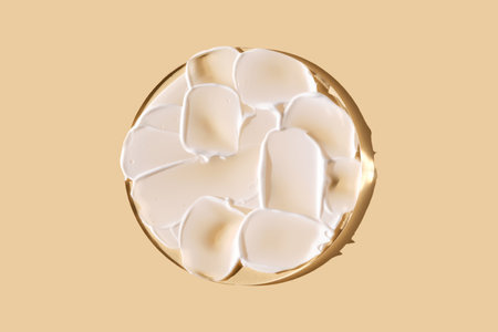 A smear of white cream on a beige background on a round stand.の写真素材
